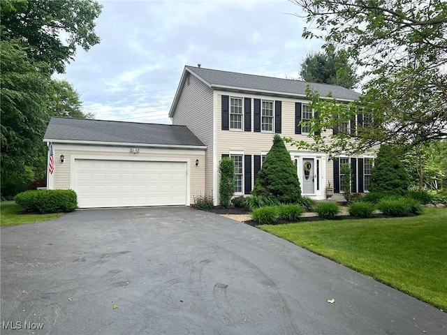 11291 Highland View Dr, Chardon, OH 44024 - colonial house featuring asphalt driveway, a garage, and a front yard