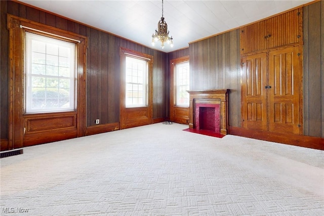 9031 State Route 213, Toronto, OH 43964 - unfurnished living room with carpet floors, a chandelier, wooden walls, and a fireplace with flush hearth