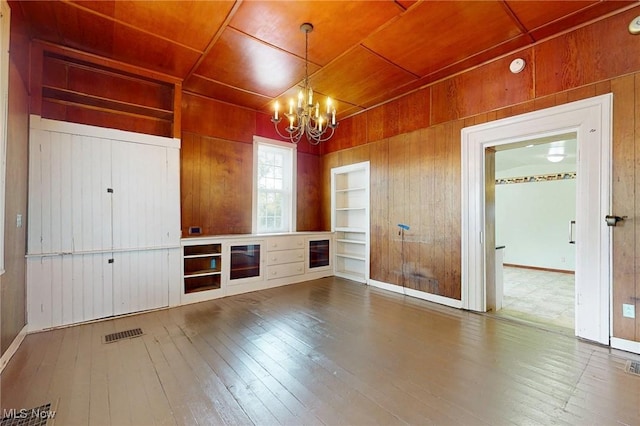 9031 State Route 213, Toronto, OH 43964 - unfurnished living room with built in features, wood walls, a chandelier, wood-type flooring, and wood ceiling