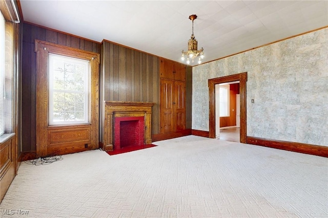 9031 State Route 213, Toronto, OH 43964 - unfurnished living room with carpet floors, a chandelier, a fireplace with flush hearth, ornamental molding, and wood walls