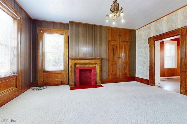 9031 State Route 213, Toronto, OH 43964 - unfurnished living room with plenty of natural light, carpet floors, crown molding, a fireplace with flush hearth, and wooden walls