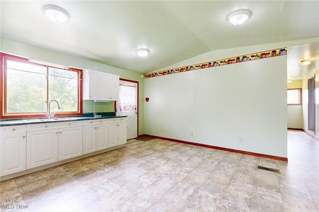 9031 State Route 213, Toronto, OH 43964 - kitchen featuring lofted ceiling, white cabinetry, a sink, dark countertops, and baseboards