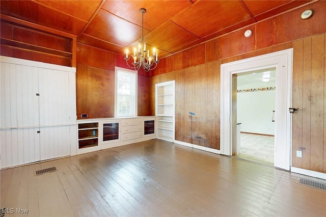 9031 State Route 213, Toronto, OH 43964 - unfurnished living room featuring wood walls, a chandelier, built in features, hardwood / wood-style floors, and wooden ceiling