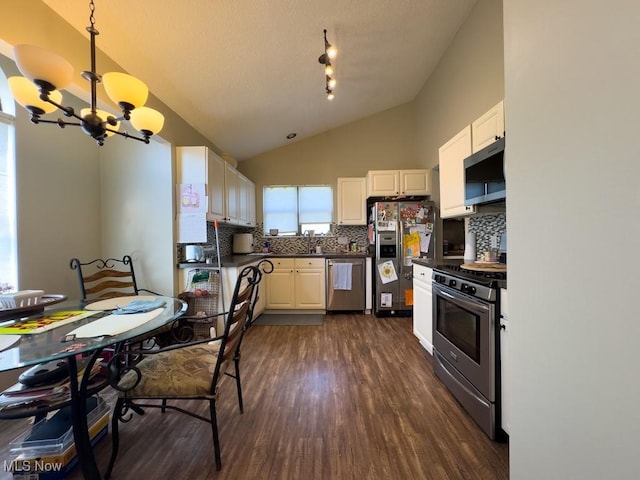 6647 Avalon St NW, Canton, OH 44708 - kitchen featuring stainless steel appliances, dark countertops, a chandelier, dark wood-type flooring, and tasteful backsplash