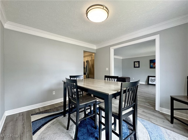 3430 E Prescott Cir, Cuyahoga Falls, OH 44223 - dining area featuring wood finished floors, baseboards, a textured ceiling, and crown molding