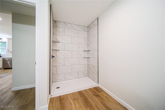433 N Buckeye, Wooster, OH 44691 - bathroom featuring wood finished floors, baseboards, and tiled shower