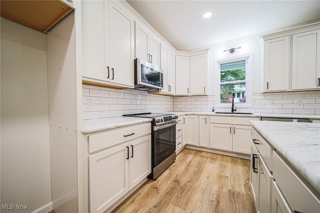 433 N Buckeye, Wooster, OH 44691 - kitchen featuring appliances with stainless steel finishes, a sink, light wood finished floors, recessed lighting, and decorative backsplash