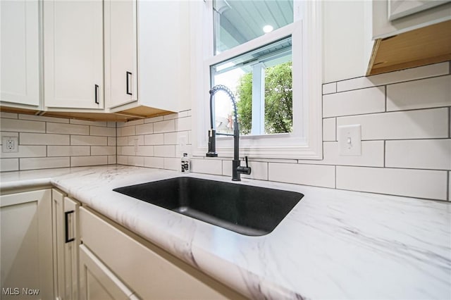 433 N Buckeye, Wooster, OH 44691 - kitchen with a sink, white cabinets, tasteful backsplash, and light stone countertops