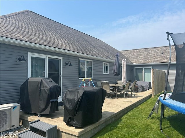 1470 Butterfield Cir, Niles, OH 44446 - rear view of property featuring a trampoline, roof with shingles, a lawn, and a cooling unit