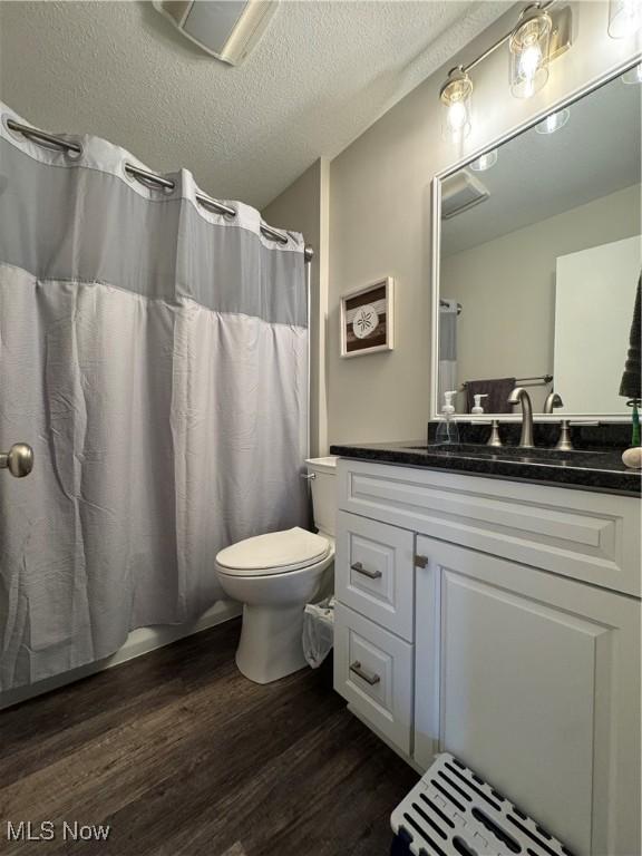 1470 Butterfield Cir, Niles, OH 44446 - bathroom with wood finished floors, toilet, vanity, and a textured ceiling