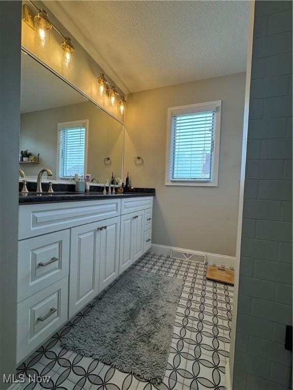 1470 Butterfield Cir, Niles, OH 44446 - full bath with double vanity, a textured ceiling, and baseboards