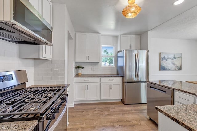 14148 Rochelle Dr, Maple Heights, OH 44137 - kitchen with appliances with stainless steel finishes, light wood-style flooring, white cabinets, dark stone countertops, and tasteful backsplash