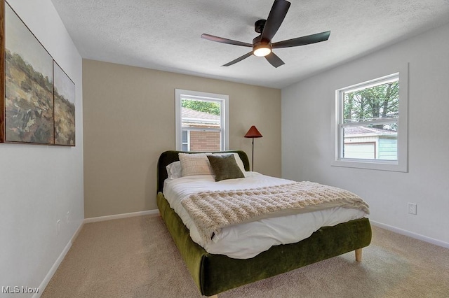 14148 Rochelle Dr, Maple Heights, OH 44137 - bedroom with light colored carpet, baseboards, ceiling fan, and a textured ceiling