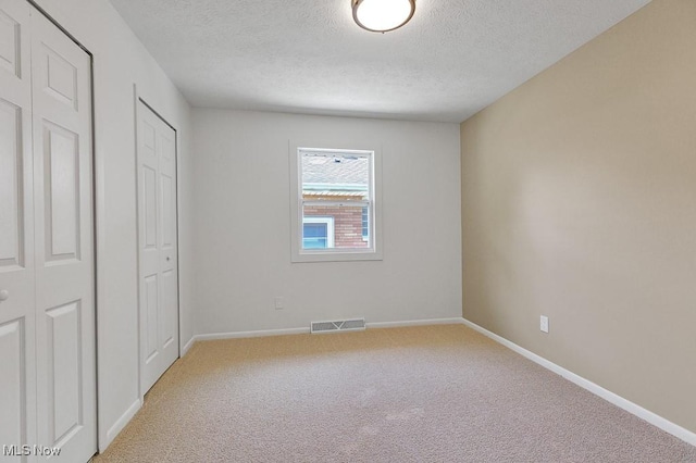 14148 Rochelle Dr, Maple Heights, OH 44137 - unfurnished bedroom featuring a textured ceiling, light colored carpet, and baseboards