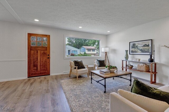 14148 Rochelle Dr, Maple Heights, OH 44137 - living room with wood finished floors, a textured ceiling, recessed lighting, and baseboards