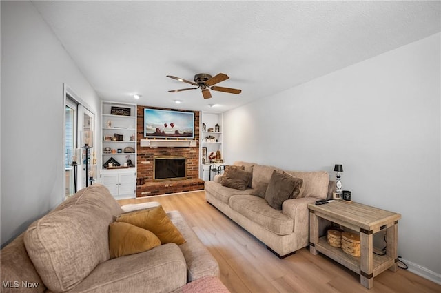 8222 Starburst Rd, Mentor, OH 44060 - living area with light wood-type flooring, a ceiling fan, and a brick fireplace
