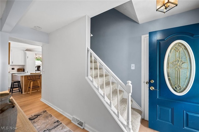 8222 Starburst Rd, Mentor, OH 44060 - entryway with light wood-type flooring, stairs, and baseboards