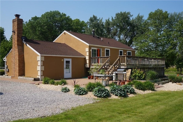 6019 New London Rd, Ashtabula, OH 44004 - back of property featuring a wooden deck, stucco siding, and a lawn