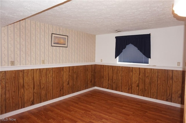 6019 New London Rd, Ashtabula, OH 44004 - spare room with a wainscoted wall, wood finished floors, a textured ceiling, and wooden walls