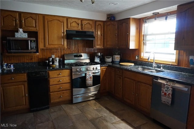6019 New London Rd, Ashtabula, OH 44004 - kitchen featuring appliances with stainless steel finishes, under cabinet range hood, a sink, brown cabinets, and a textured ceiling