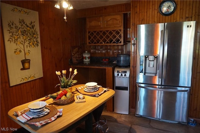 6019 New London Rd, Ashtabula, OH 44004 - kitchen featuring stainless steel fridge with ice dispenser, wood walls, brown cabinetry, and ceiling fan