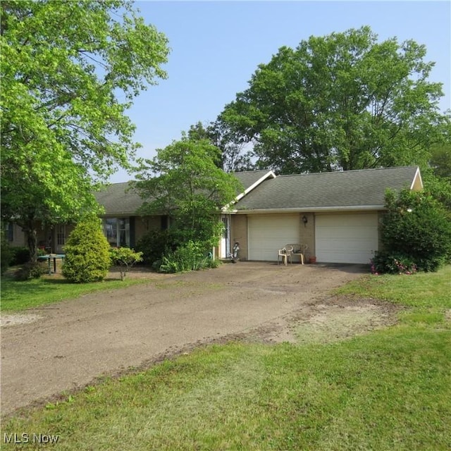 576 12th St NW, Carrollton, OH 44615 - view of front of home with driveway, an attached garage, and a front lawn