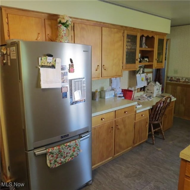 576 12th St NW, Carrollton, OH 44615 - kitchen with freestanding refrigerator, light countertops, brown cabinetry, glass insert cabinets, and a desk
