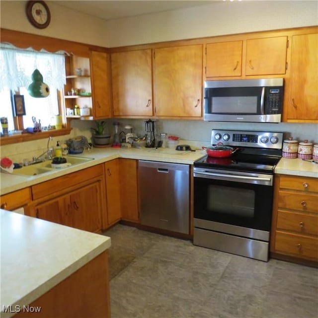 576 12th St NW, Carrollton, OH 44615 - kitchen featuring appliances with stainless steel finishes, a sink, light countertops, brown cabinetry, and open shelves