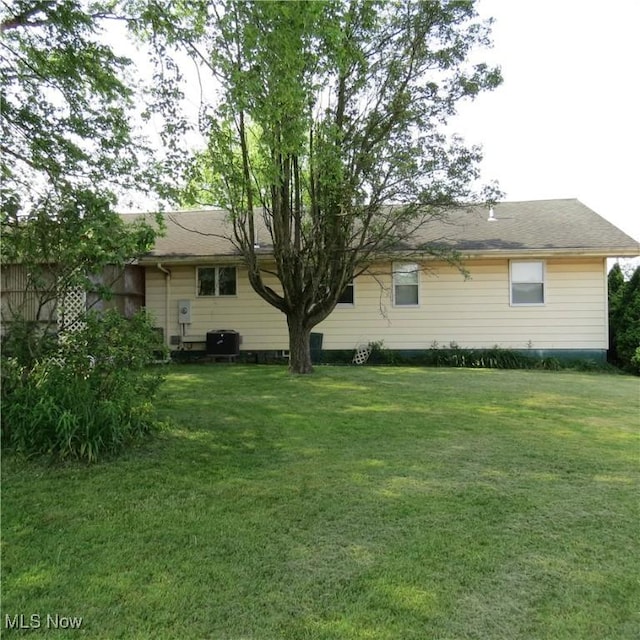 576 12th St NW, Carrollton, OH 44615 - rear view of property with a yard and central AC unit