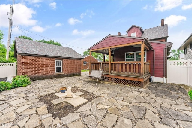 97 Overlook Blvd, Struthers, OH 44471 - back of house with a patio area, a wooden deck, roof with shingles, a chimney, and brick siding