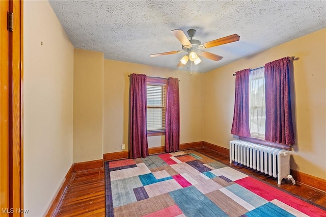 97 Overlook Blvd, Struthers, OH 44471 - empty room featuring radiator, ceiling fan, hardwood / wood-style floors, baseboards, and a textured ceiling