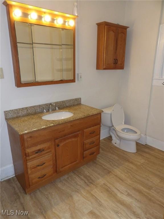 974 E Archwood Ave, Akron, OH 44306 - bathroom featuring vanity, toilet, wood finished floors, and baseboards