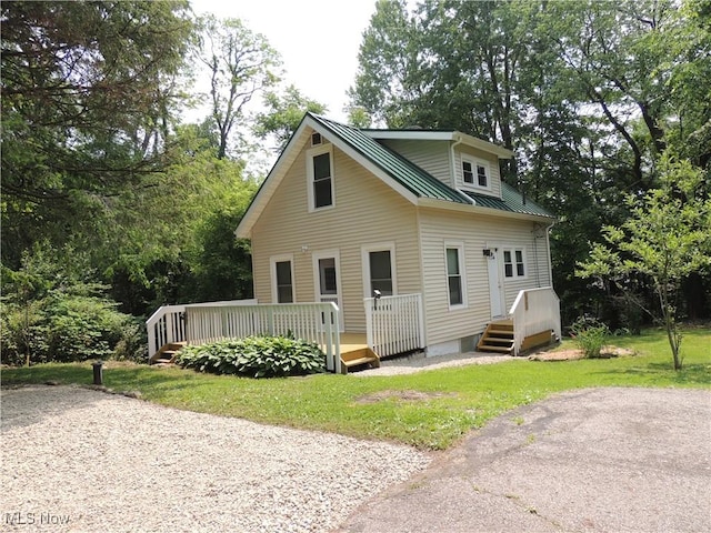 2242 Coffeen St, Kent, OH 44240 - bungalow-style home featuring a front yard, metal roof, a deck, and view of wooded area