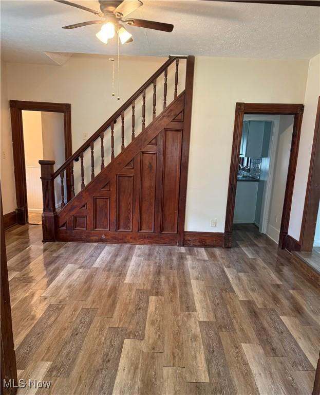 533 W Park Ave, Niles, OH 44446 - interior space featuring a ceiling fan, baseboards, stairway, wood finished floors, and a textured ceiling