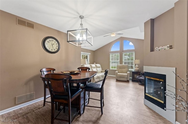 4044 Saint Andrews Ct, Canfield, OH 44406 - dining space featuring a multi sided fireplace, lofted ceiling, baseboards, a chandelier, and a ceiling fan