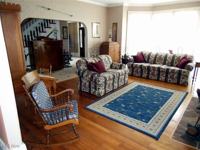 518 Hill St, Coshocton, OH 43812 - living area featuring arched walkways, wallpapered walls, crown molding, stairway, and wood finished floors