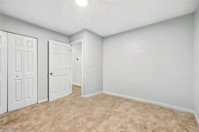 4438-4440 Washington Square Dr, Austintown, OH 44515 - unfurnished bedroom featuring light carpet, baseboards, and a closet