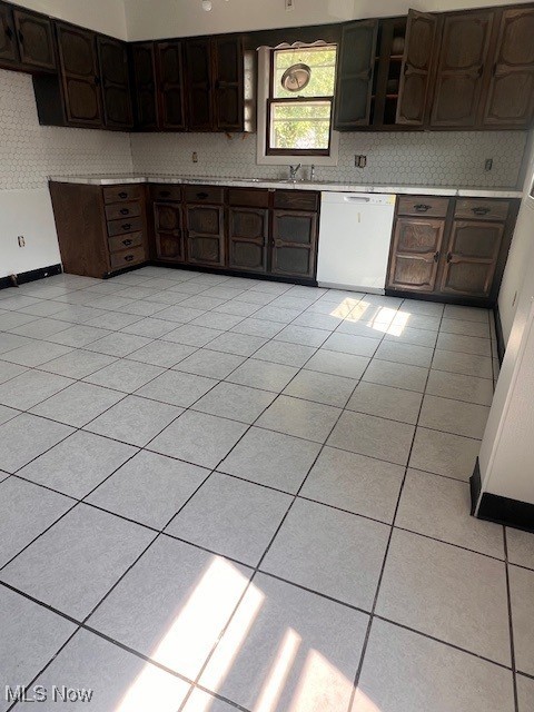 296 Sanderson Ave, Campbell, OH 44405 - kitchen featuring white dishwasher, tasteful backsplash, light countertops, dark brown cabinets, and light tile patterned floors