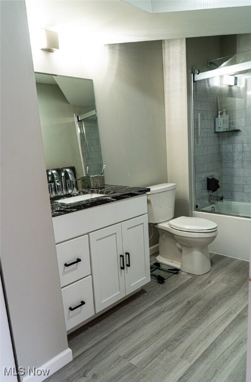 2337 W 11th St Unit 6, Cleveland, OH 44113 - full bathroom with wood finished floors, toilet, vanity, washtub / shower combination, and baseboards
