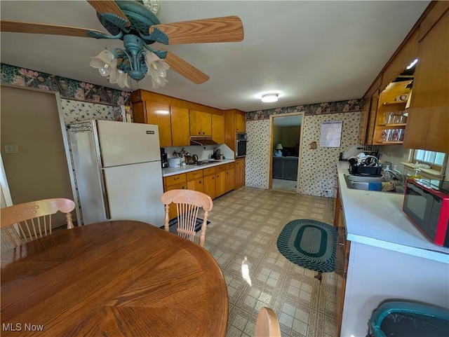 5710 Sugargrove Rd, Blue Rock, OH 43720 - kitchen featuring freestanding refrigerator, wall oven, wallpapered walls, light countertops, and brown cabinets
