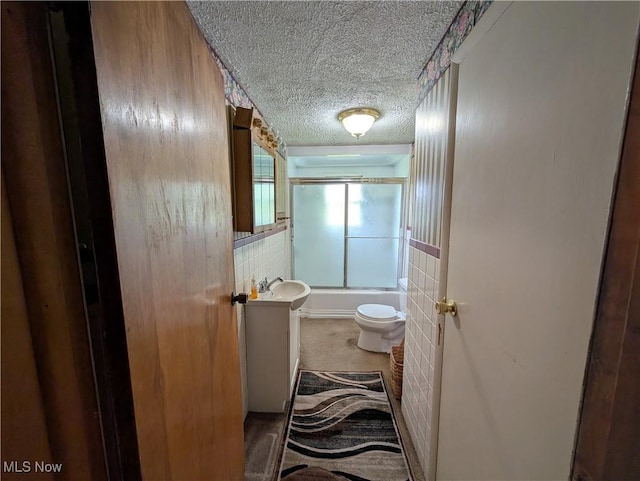 5710 Sugargrove Rd, Blue Rock, OH 43720 - bathroom with a textured ceiling, vanity, combined bath / shower with glass door, toilet, and tile walls