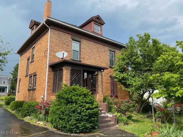 705 Main St, Toronto, OH 43964 - view of property exterior with brick siding and a chimney