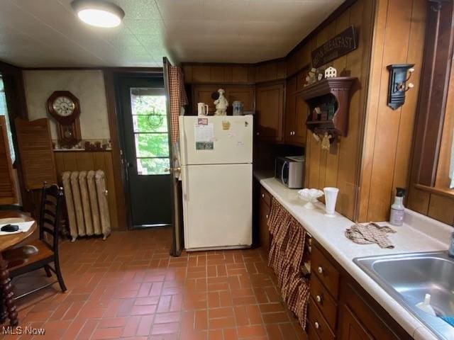 705 Main St, Toronto, OH 43964 - kitchen with freestanding refrigerator, radiator heating unit, brick patterned floors, a sink, and light countertops