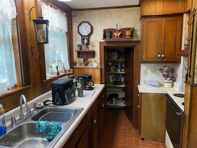 705 Main St, Toronto, OH 43964 - kitchen with white electric range oven, a sink, brown cabinets, light countertops, and brick patterned floors