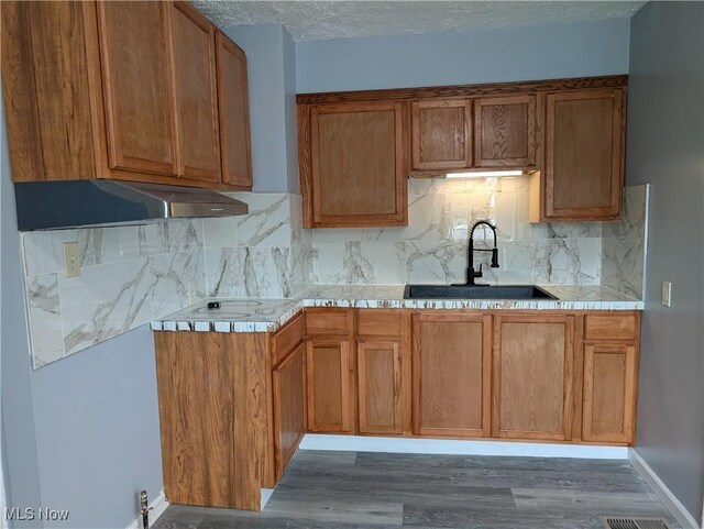 727 N Firestone Blvd, Akron, OH 44306 - kitchen featuring a sink, tasteful backsplash, wood finished floors, and a textured ceiling