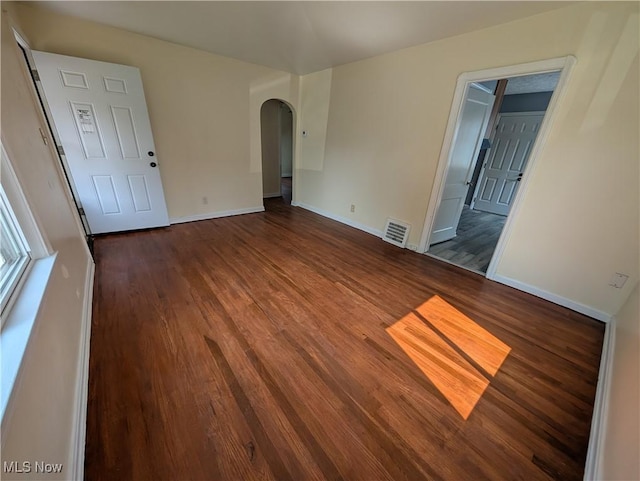 727 N Firestone Blvd, Akron, OH 44306 - unfurnished room featuring arched walkways, dark wood-type flooring, and baseboards