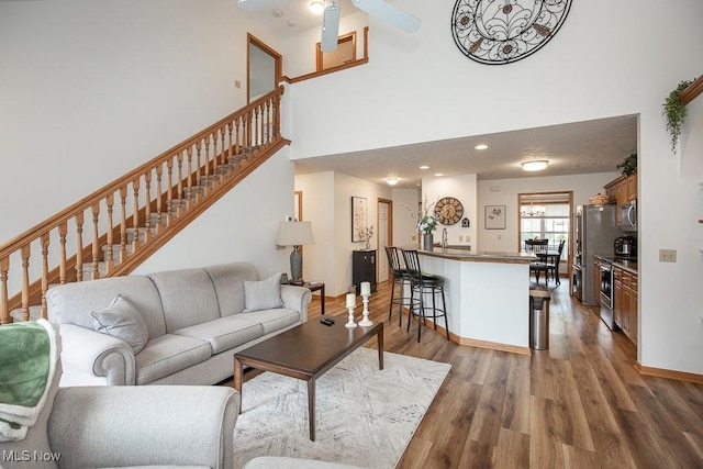 2401 Bunker Ln Unit B, Willoughby, OH 44094 - living room with dark wood finished floors, stairs, a towering ceiling, ceiling fan, and baseboards