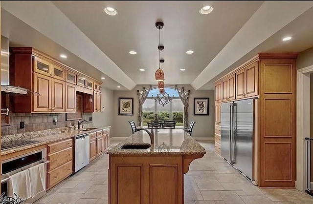 8320 Westfield Rd, Seville, OH 44273 - kitchen featuring stainless steel appliances, wall chimney exhaust hood, light stone countertops, an island with sink, and decorative backsplash