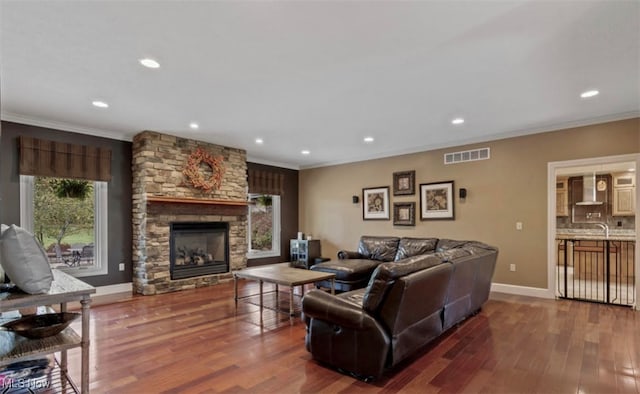 8320 Westfield Rd, Seville, OH 44273 - living room featuring wood finished floors, a stone fireplace, crown molding, recessed lighting, and baseboards