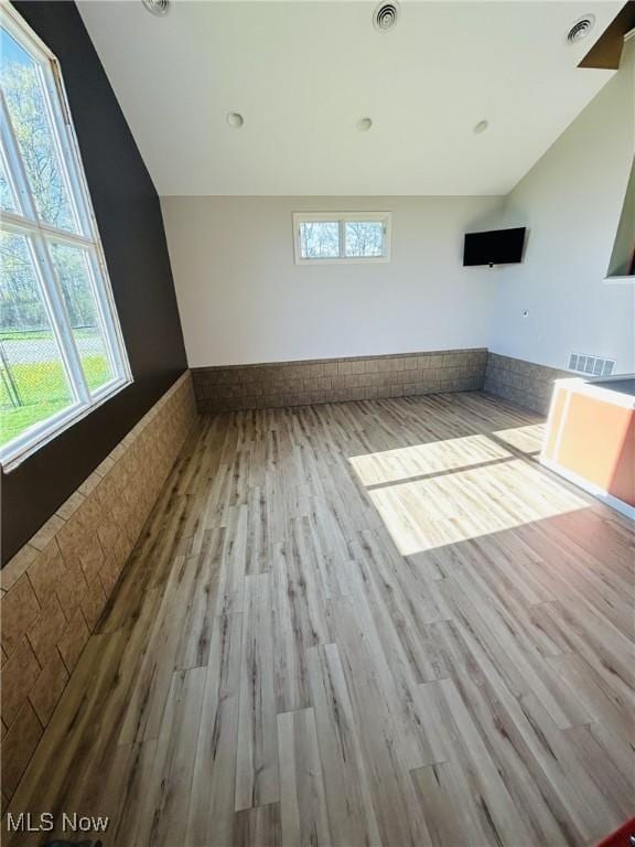 8320 Westfield Rd, Seville, OH 44273 - unfurnished living room featuring wood finished floors, healthy amount of natural light, and lofted ceiling
